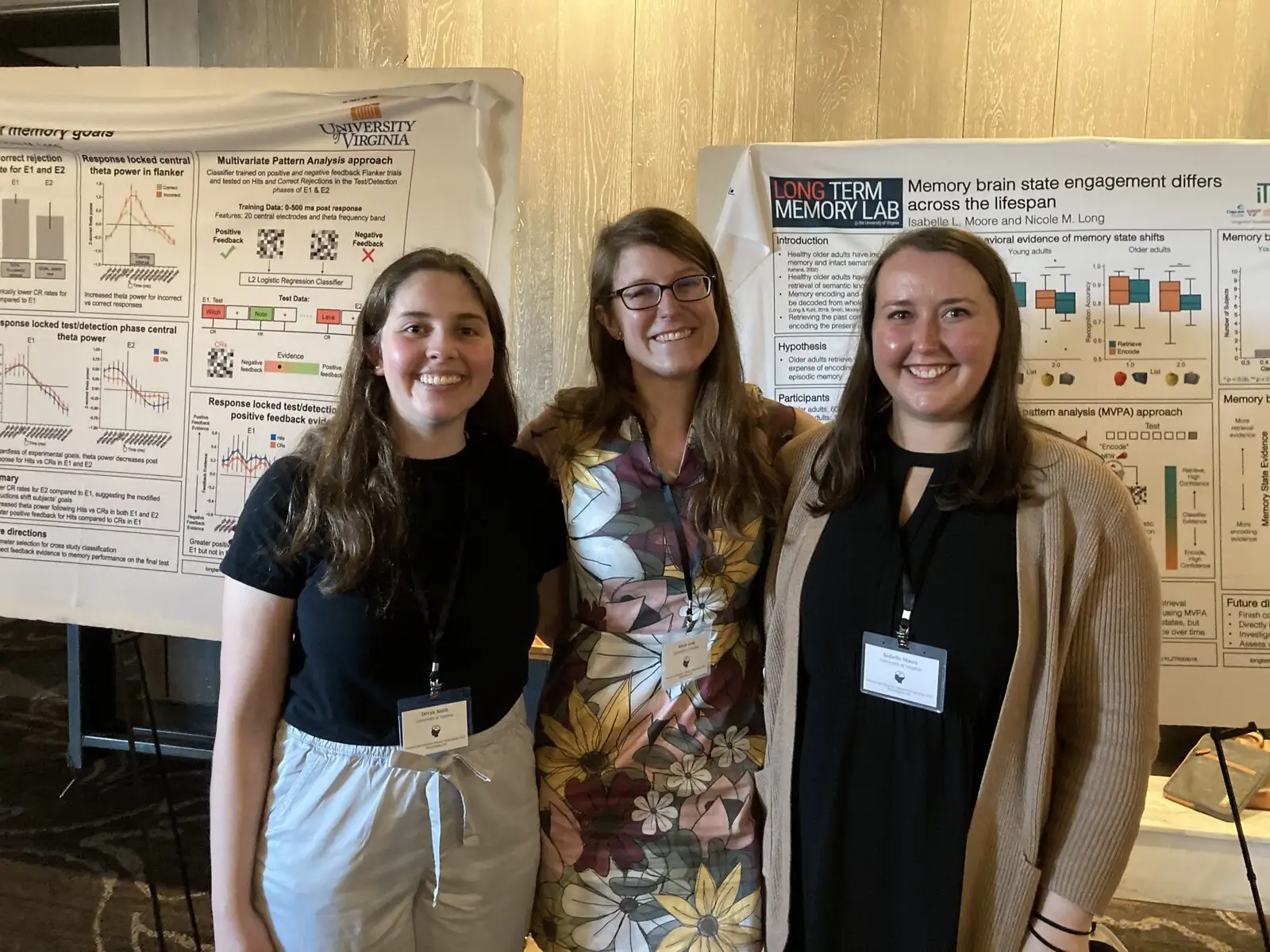 Researchers standing in front of their poster in a conference hall