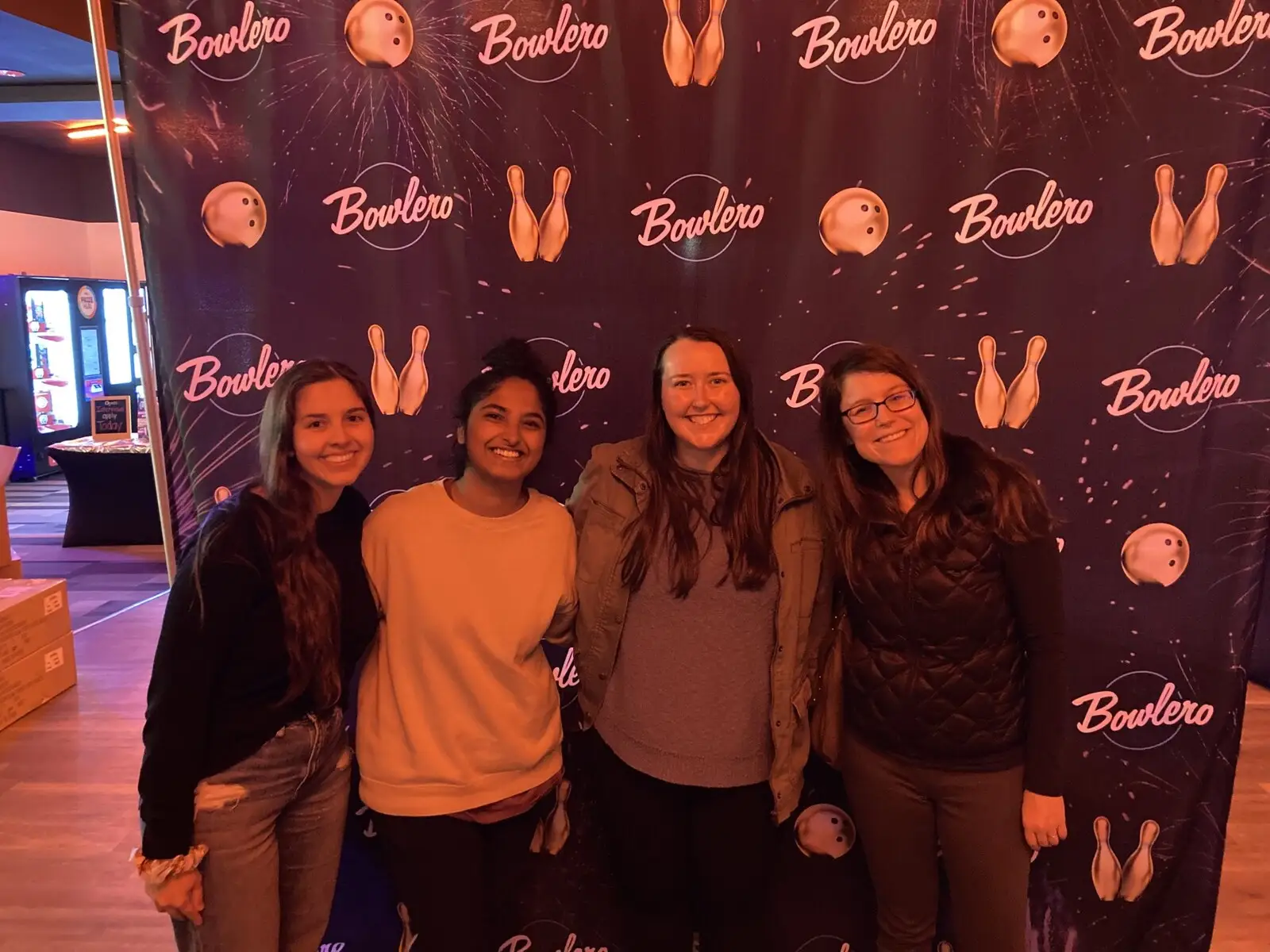 Four lab members posing in front of a Bowlero backdrop