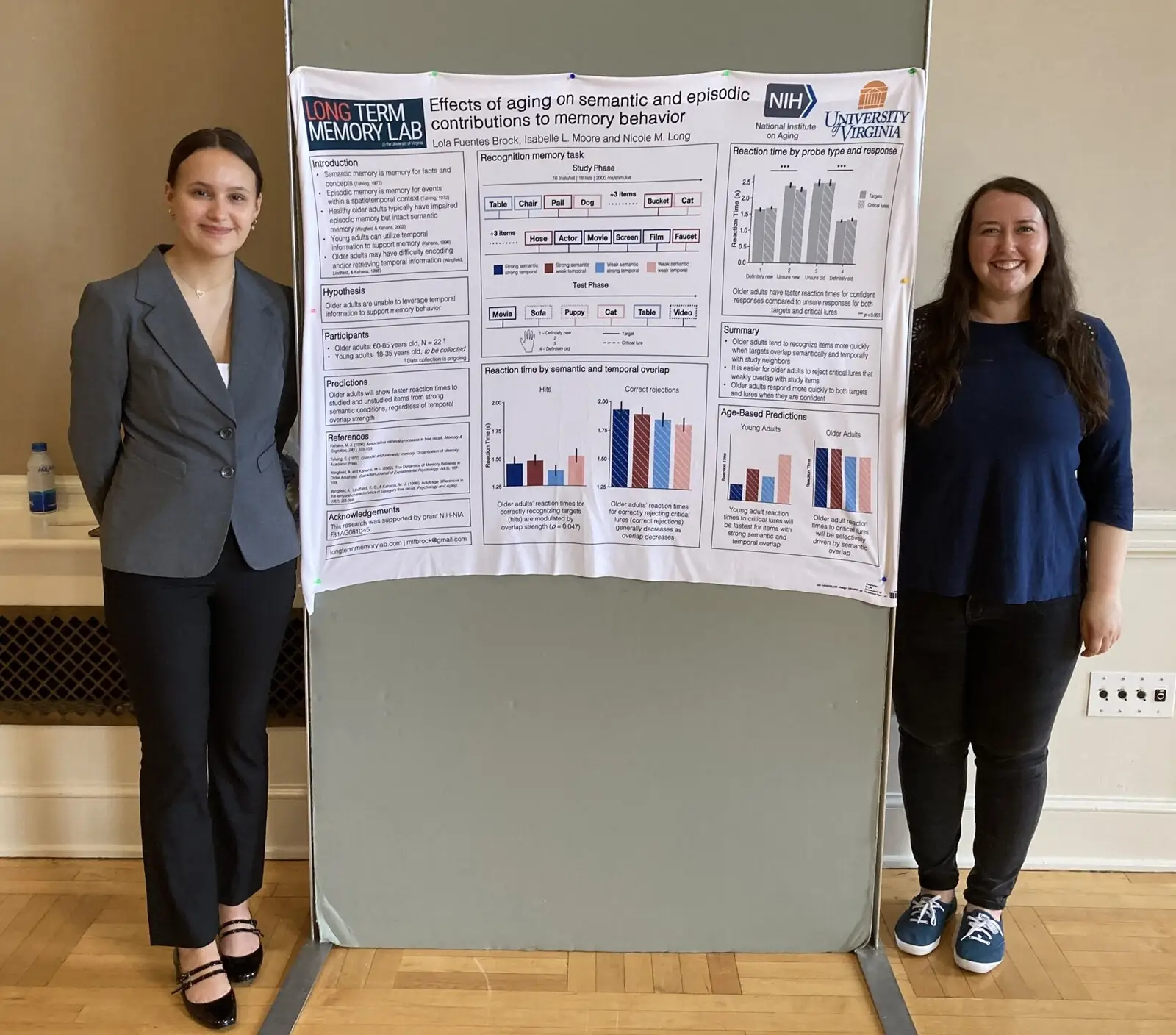 Two students standing either side of a research poster on an easel