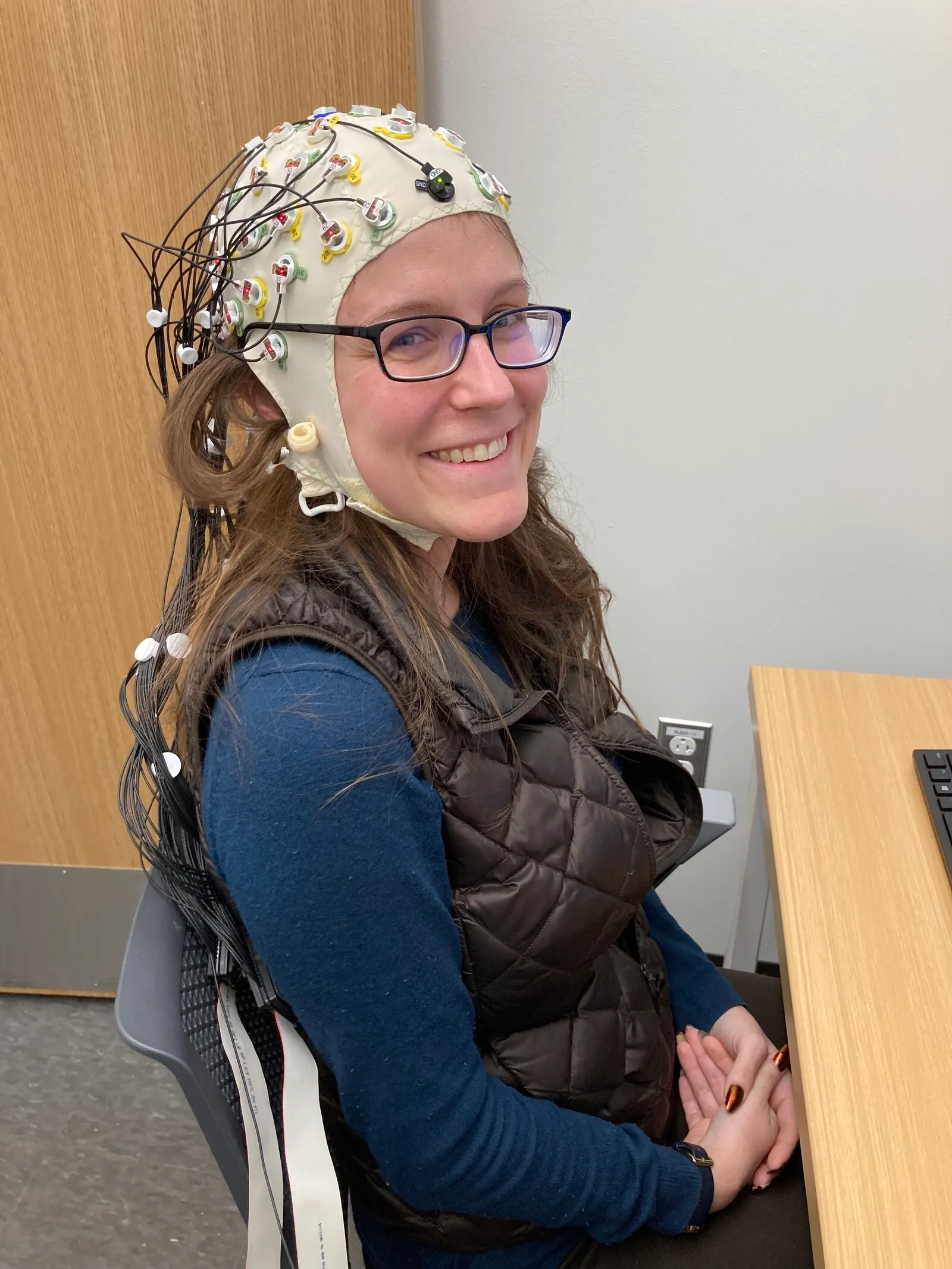 A participant wearing an EEG cap fitted with electrodes.